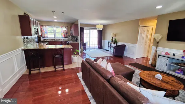 a living room with furniture a flat screen tv and kitchen view