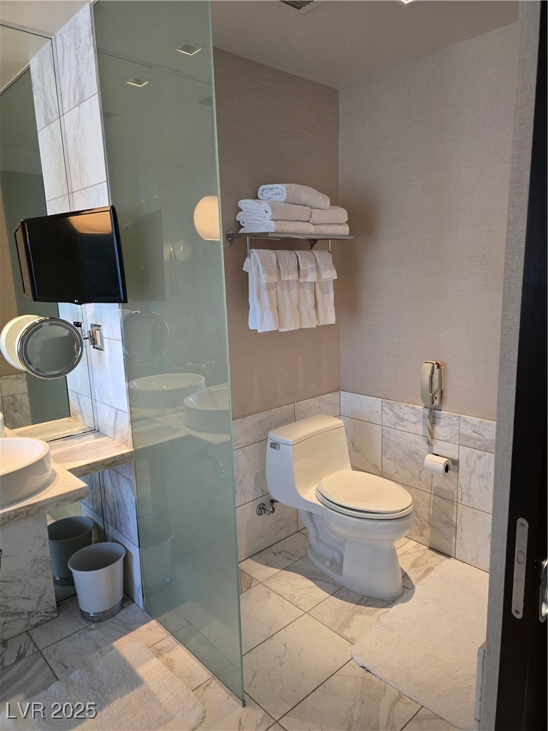 4381 West Flamingo Road, Unit 3109 Las Vegas, NV 89103 - Photo 16 of 28 Bathroom with marble finish floor, wainscoting, and tile walls