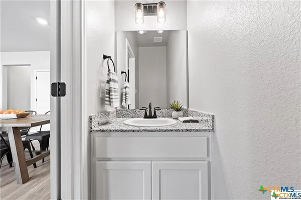 a bathroom with a granite countertop sink and a mirror