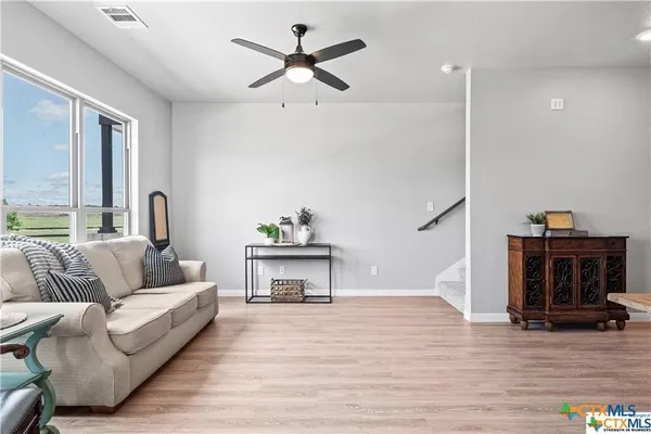 a living room with furniture and a wooden floor