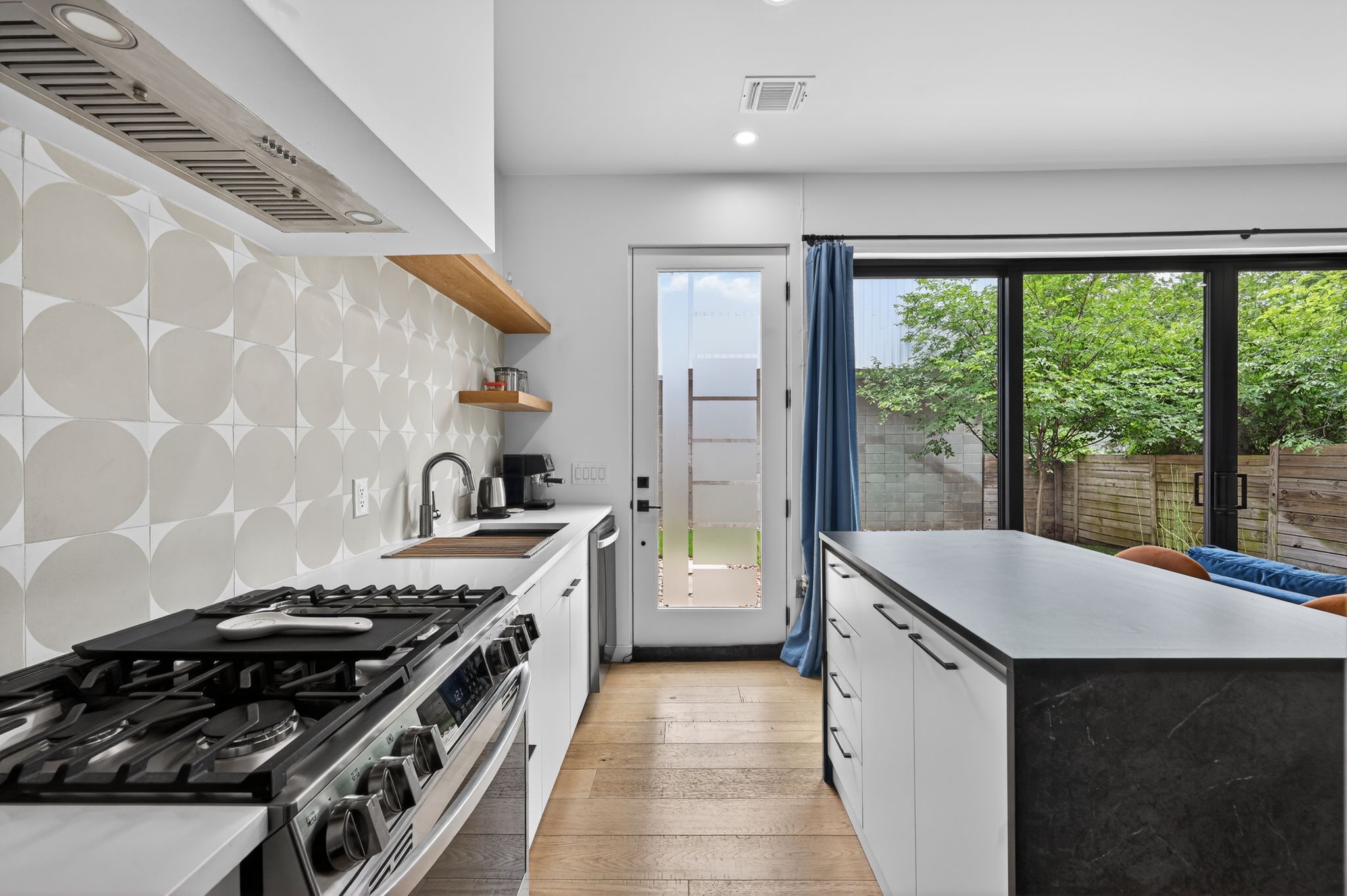 1206 Luna Street, Unit 2 Austin, TX 78721 - Photo 19 of 30 The kitchen features a stainless steel range and hood, white countertops, and a patterned tile backsplash