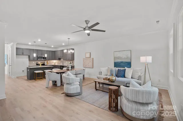 a living room with furniture and kitchen view