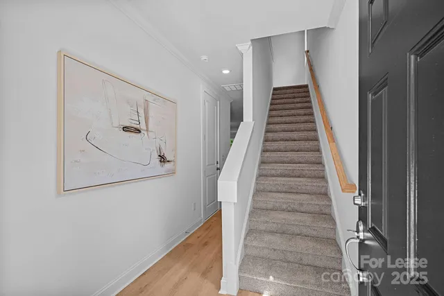 a view of staircase with wooden floor and white walls
