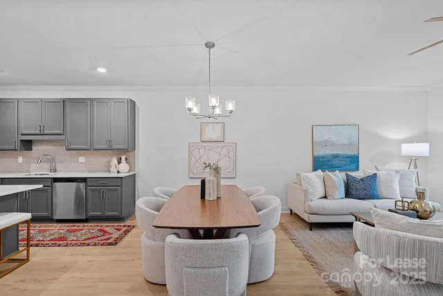 a kitchen with stainless steel appliances granite countertop a sink a stove a refrigerator and a chandelier