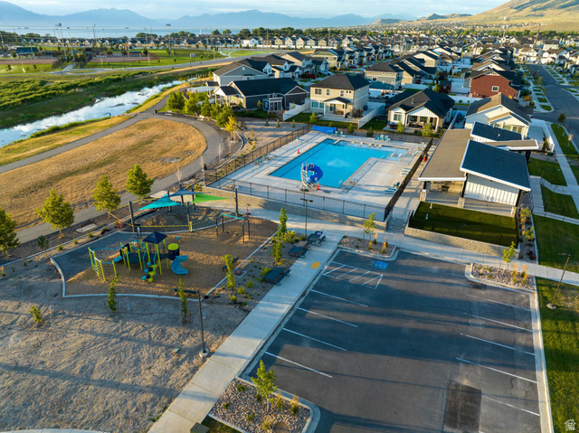 82 Provo River Road, Unit 251 Saratoga Springs, UT 84045 - Photo 30 of 32 Community pool with a water feature, adjacent clubhouse, and a dedicated parking area