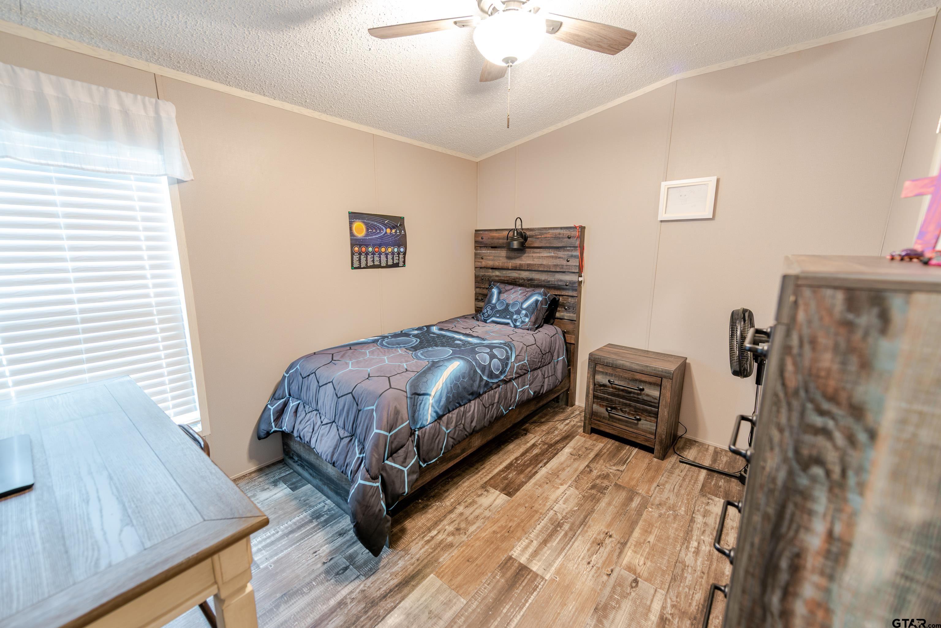 108 Sandy Brown Road Scroggins, TX 75480 - Photo 14 of 17 a bedroom with a bed and a chandelier