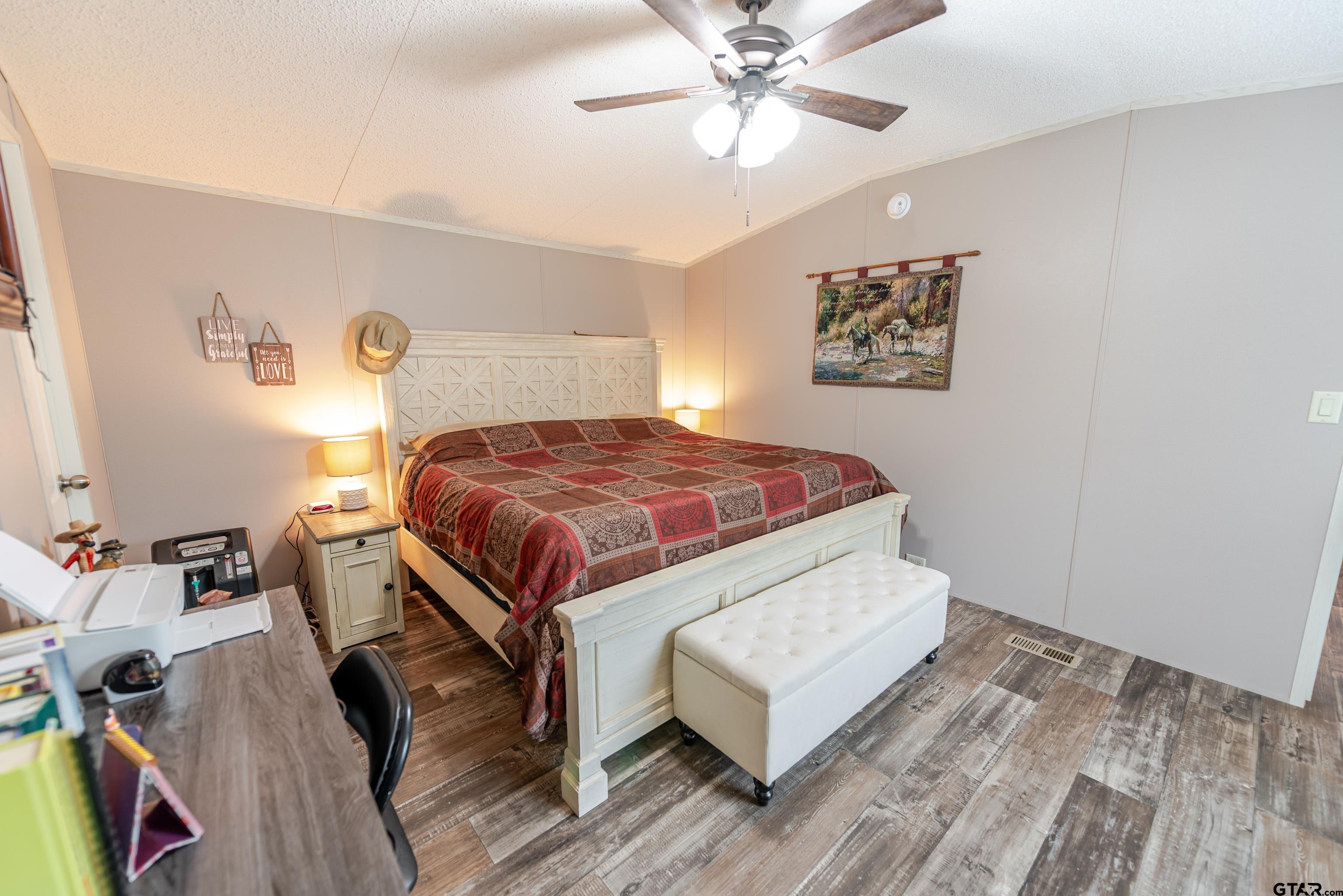 108 Sandy Brown Road Scroggins, TX 75480 - Photo 9 of 17 a bedroom with a bed and a chandelier