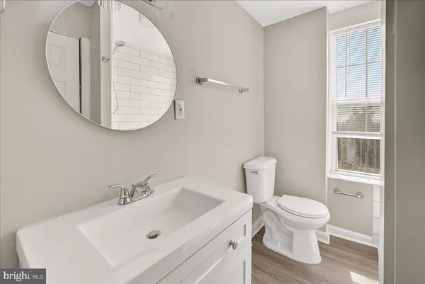 a bathroom with a sink a toilet and a mirror