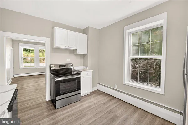a kitchen with a stove a sink and a window