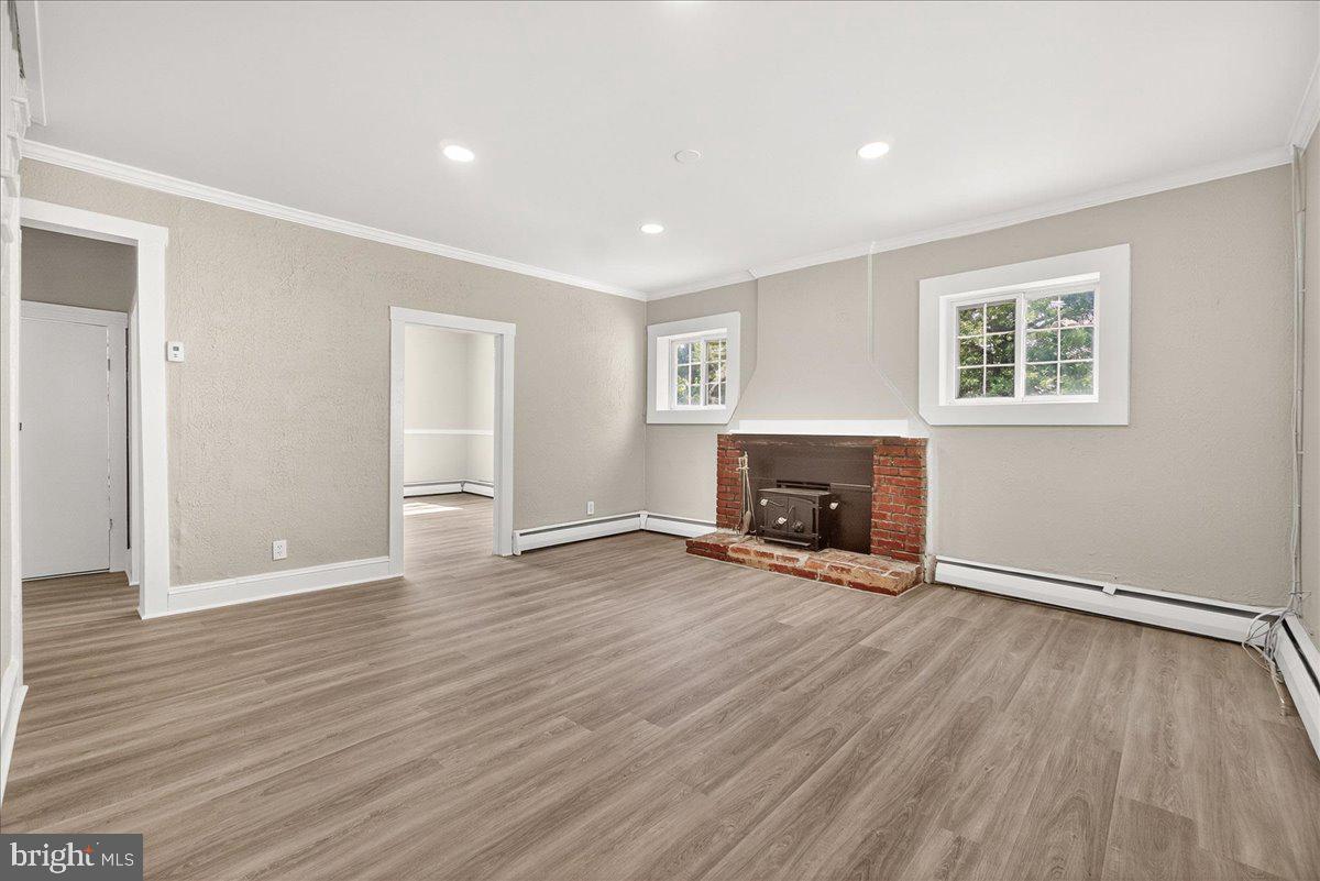 6215 South Clifton Road Braddock Heights, MD 21703 - Photo 5 of 46 an empty room with wooden floor and a fireplace