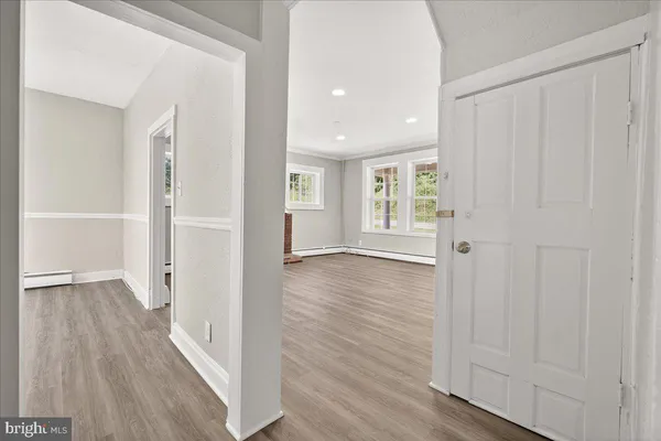 a view of a hallway with wooden floor and closet area