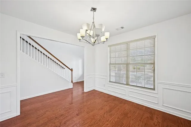a view of an empty room with a fireplace and wooden floor