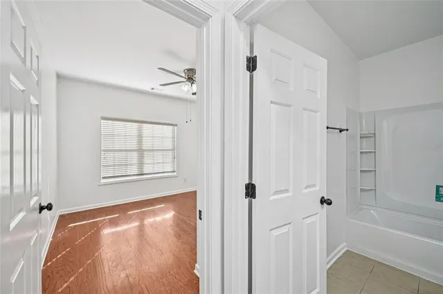 a view of a hallway with wooden floor and a living room