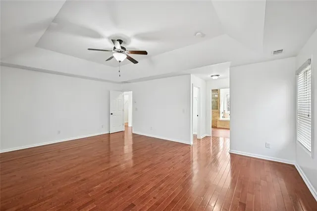 a view of a hallway with wooden floor and staircase