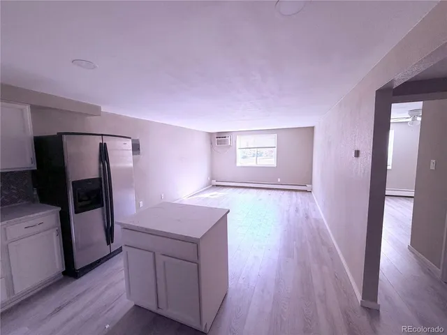 a kitchen with a wooden floor and electronic appliances