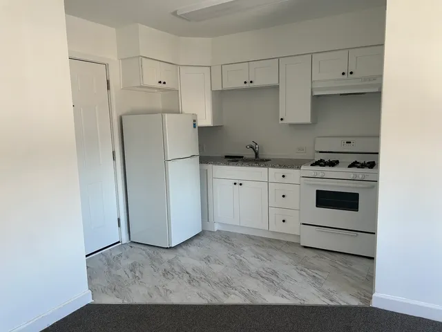 a kitchen with white cabinets and white appliances