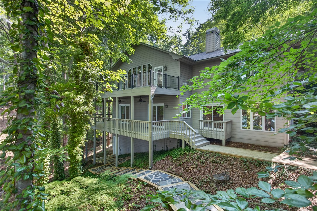 12 Lookout Lane Salem, SC 29676 - Photo 2 of 47 Perched among the trees, this multi-level home features expansive decks and a charming stone pathway.