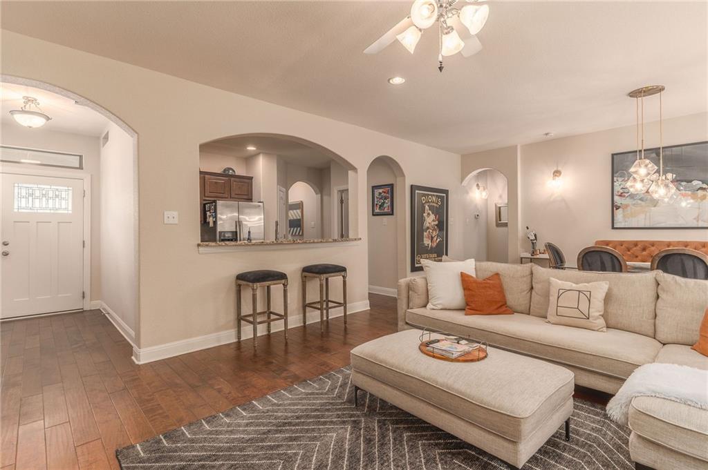 6708 Menchaca Road, Unit 14 Austin, TX 78745 - Photo 19 of 22 Open concept living area featuring wood-finish flooring, arched doorways, a built-in breakfast bar with a granite-style countertop, and recessed lighting