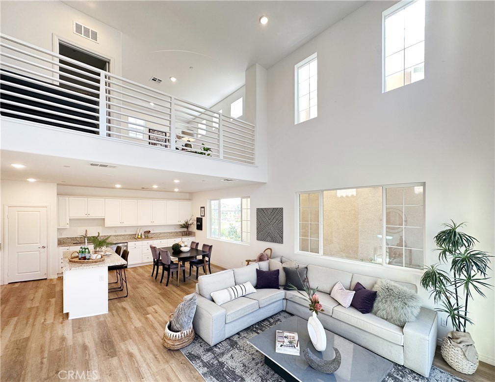 a living room with furniture kitchen view and a large window