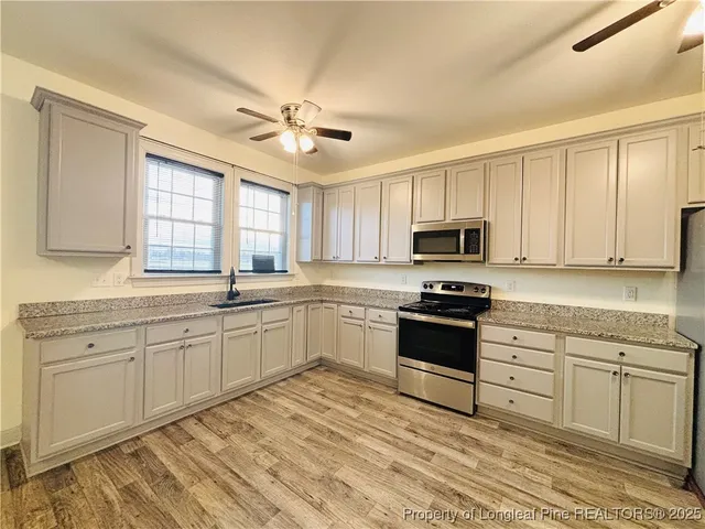 a kitchen with granite countertop white cabinets and white appliances