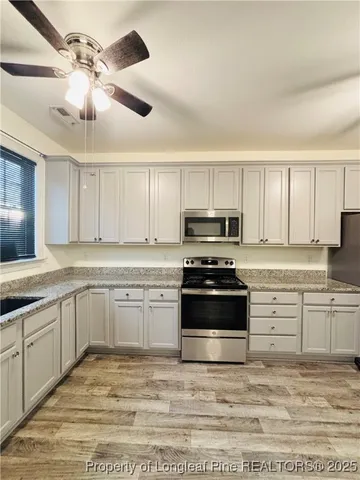 a kitchen with stainless steel appliances granite countertop a stove sink microwave and cabinets