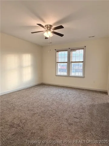 a view of a livingroom with a ceiling fan and window