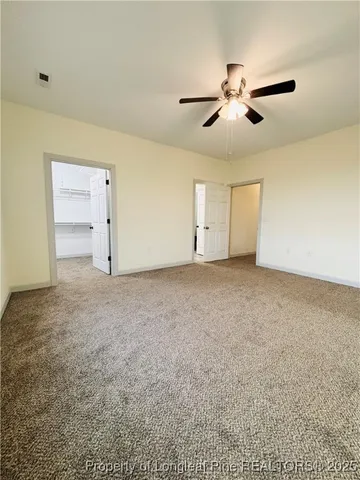 an empty room with a ceiling fan and window