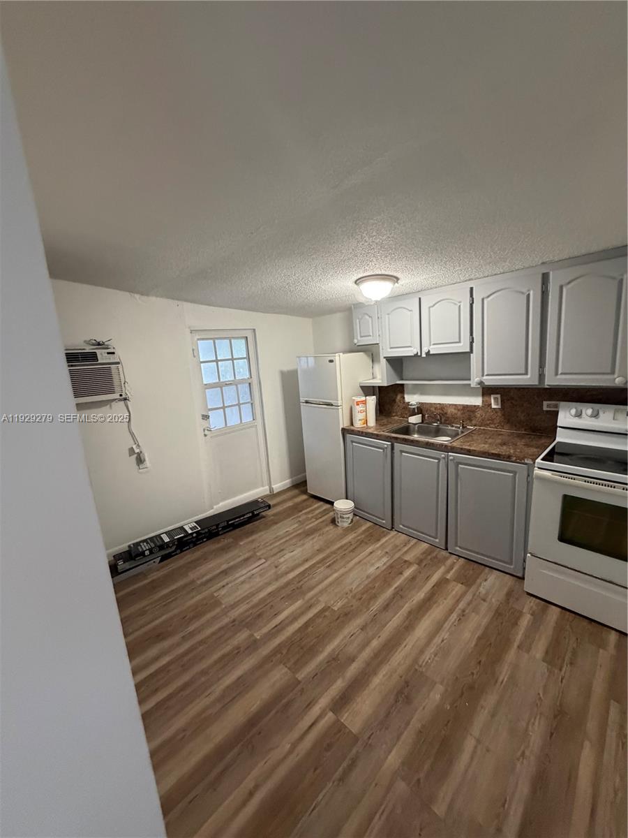 2980 Northwest 79th Street, Unit A Miami, FL 33147 - Photo 2 of 7 a kitchen with granite countertop a sink stainless steel appliances and cabinets