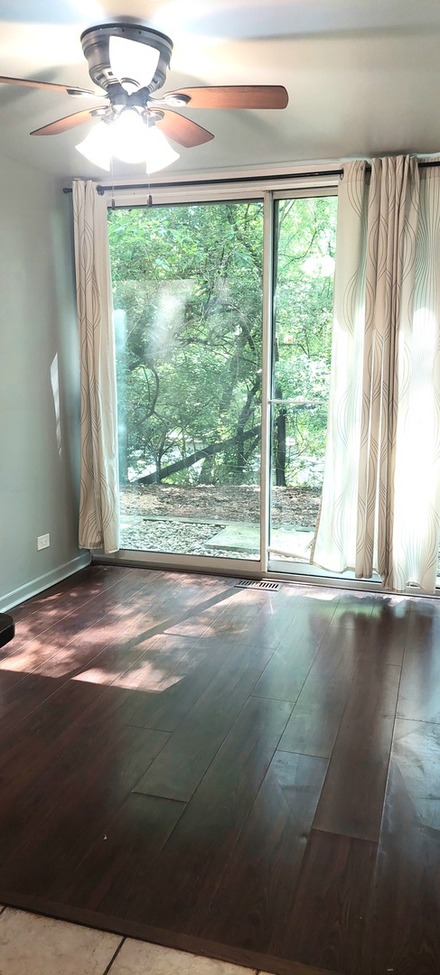 6010 Forest View Road, Unit 1A Lisle, IL 60532 - Photo 9 of 39 a view of empty room with wooden floor and fan