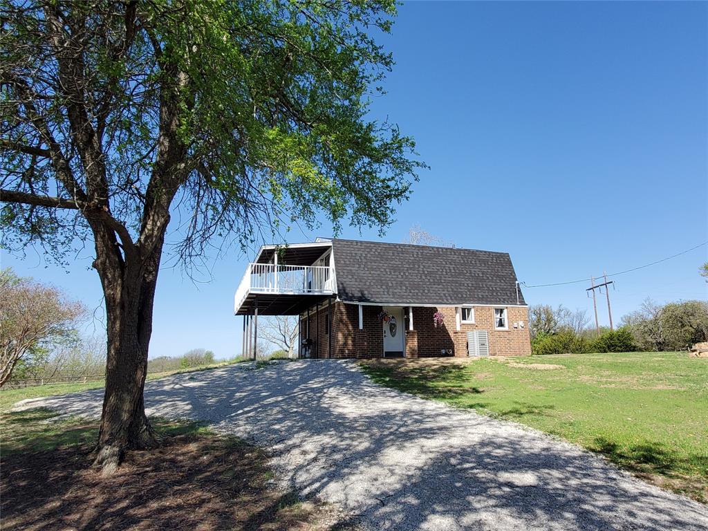 1353 Friendship Road Weatherford, TX 76085 - Photo 1 of 29 Brick residence with a prominent second-story balcony featuring white railings