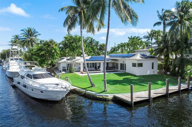 an aerial view of a house with a yard and lake view