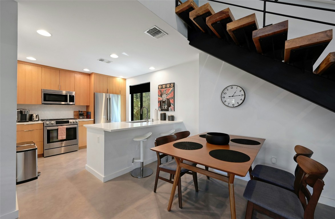 407 South Park Drive, Unit 2 Austin, TX 78704 - Photo 11 of 25 a kitchen with stainless steel appliances kitchen island a table and chairs in it
