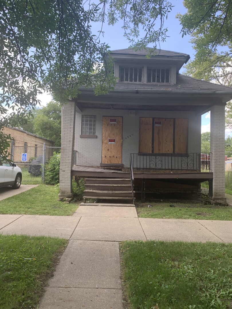 a view of backyard with table and chairs and a large tree