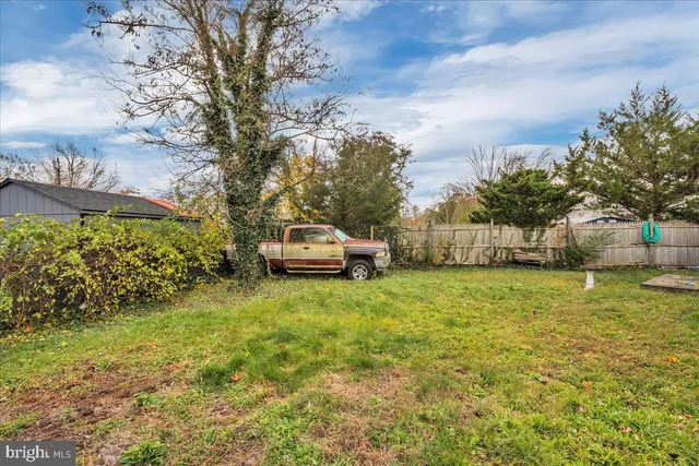 a car parked in front of a house with a big yard