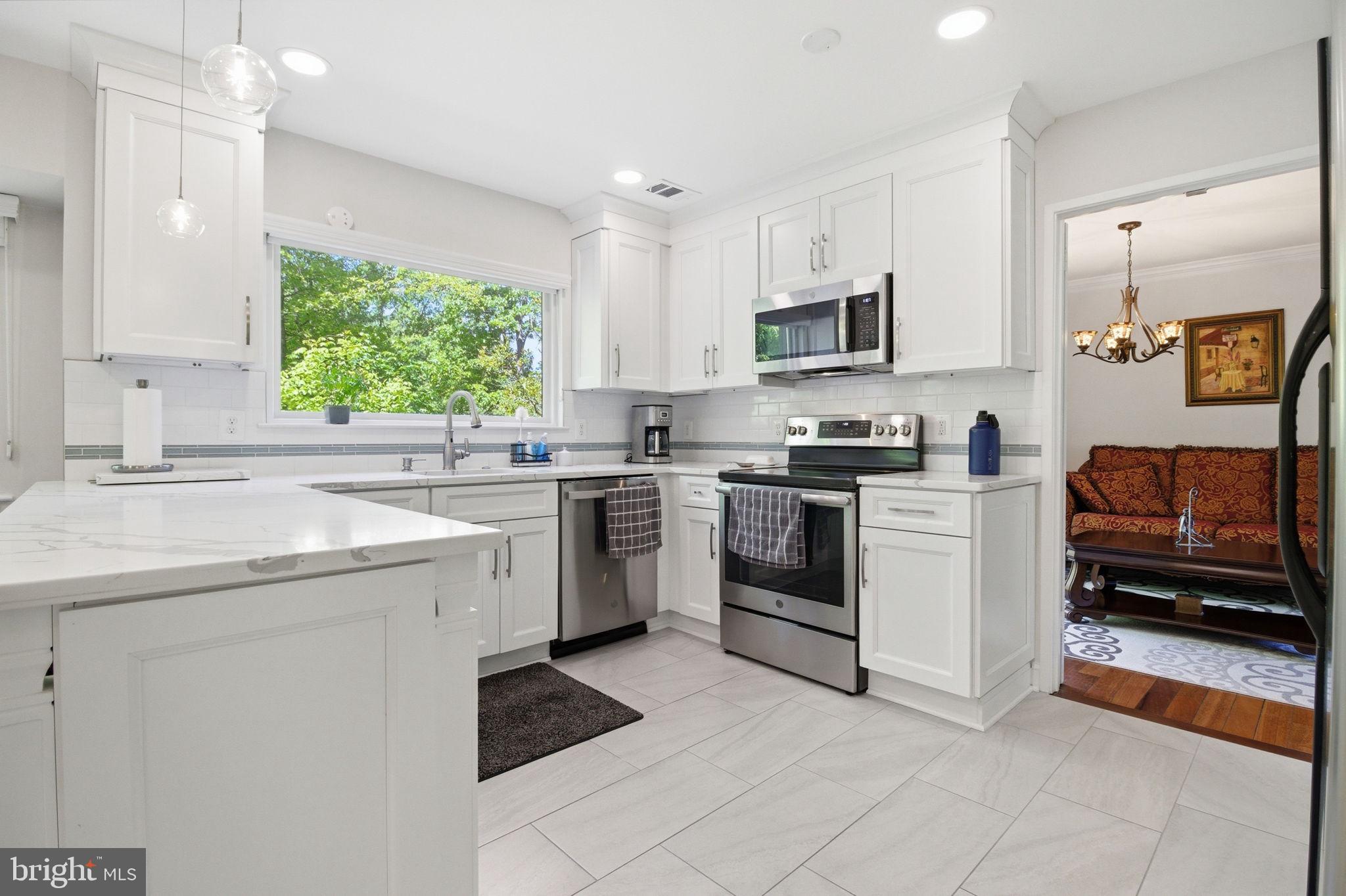 1509 Farsta Court Reston, VA 20190 - Photo 8 of 40 a kitchen with a sink white cabinets and white appliances