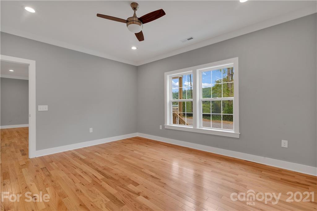 296 Ridge View Drive, Unit 7 Clyde, NC 28721 - Photo 15 of 19 an empty room with window and a ceiling fan