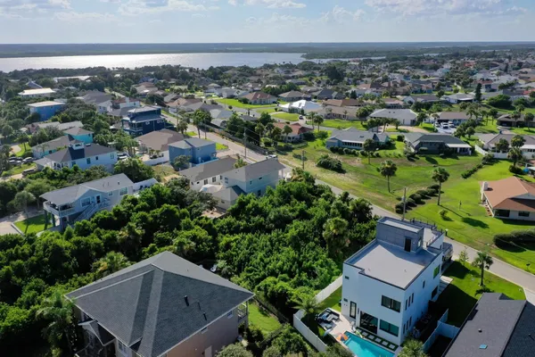 an aerial view of residential houses with outdoor space and trees
