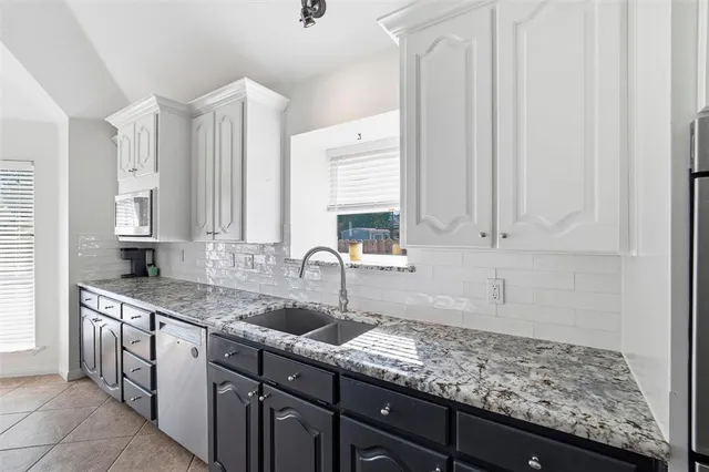 a kitchen with stainless steel appliances granite countertop a sink and dishwasher with wooden floor