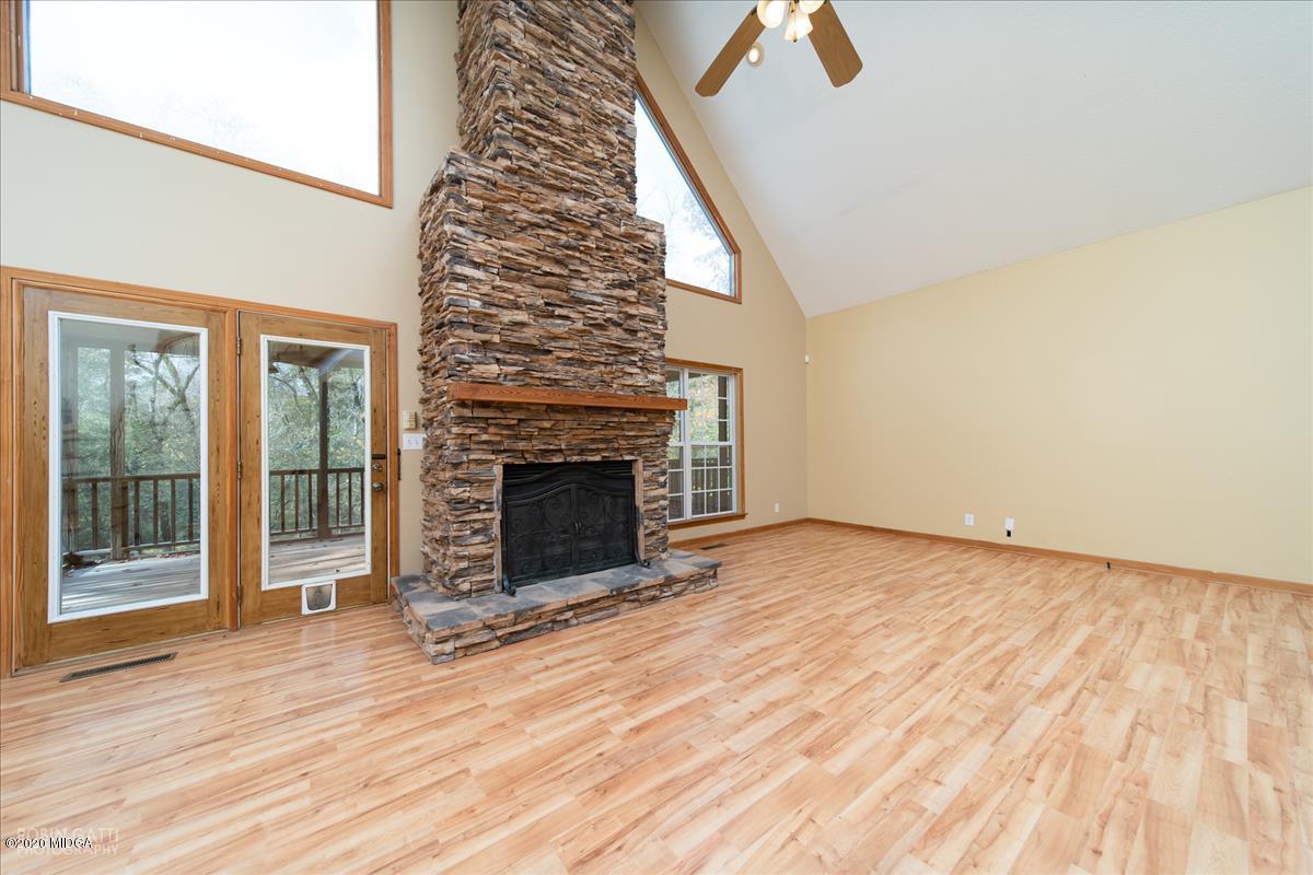 146 Old Graham Road Gray, GA 31032 - Photo 3 of 33 an empty room with wooden floor fireplace and windows