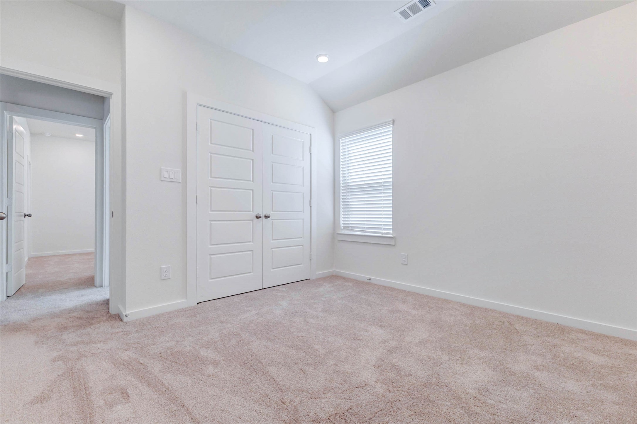 6467 Escondido Drive Rosharon, TX 77583 - Photo 24 of 32 Secondary bedroom with soft carpet, high ceiling, window with blinds, double-door closet, and neutral walls. The room offers flexible use as a guest room, child’s room, home office, nursery, or hobby space, with bright natural light and an easy-to-personalize layout.