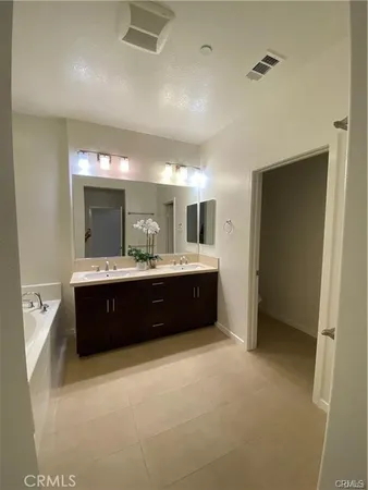 a spacious bathroom with a double vanity sink and mirror