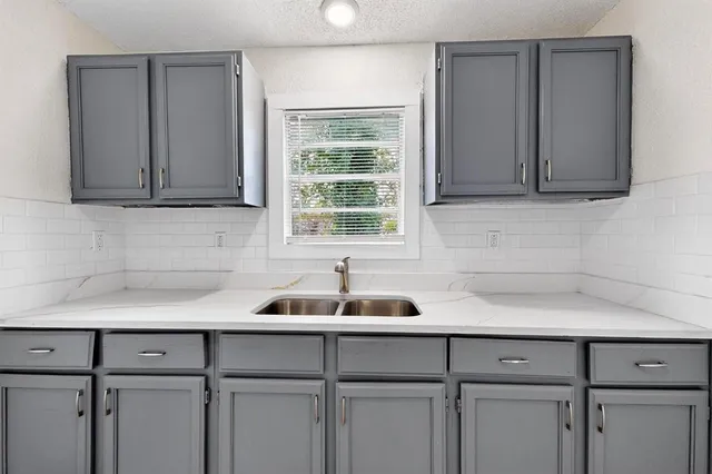 a kitchen with a sink cabinets and a window