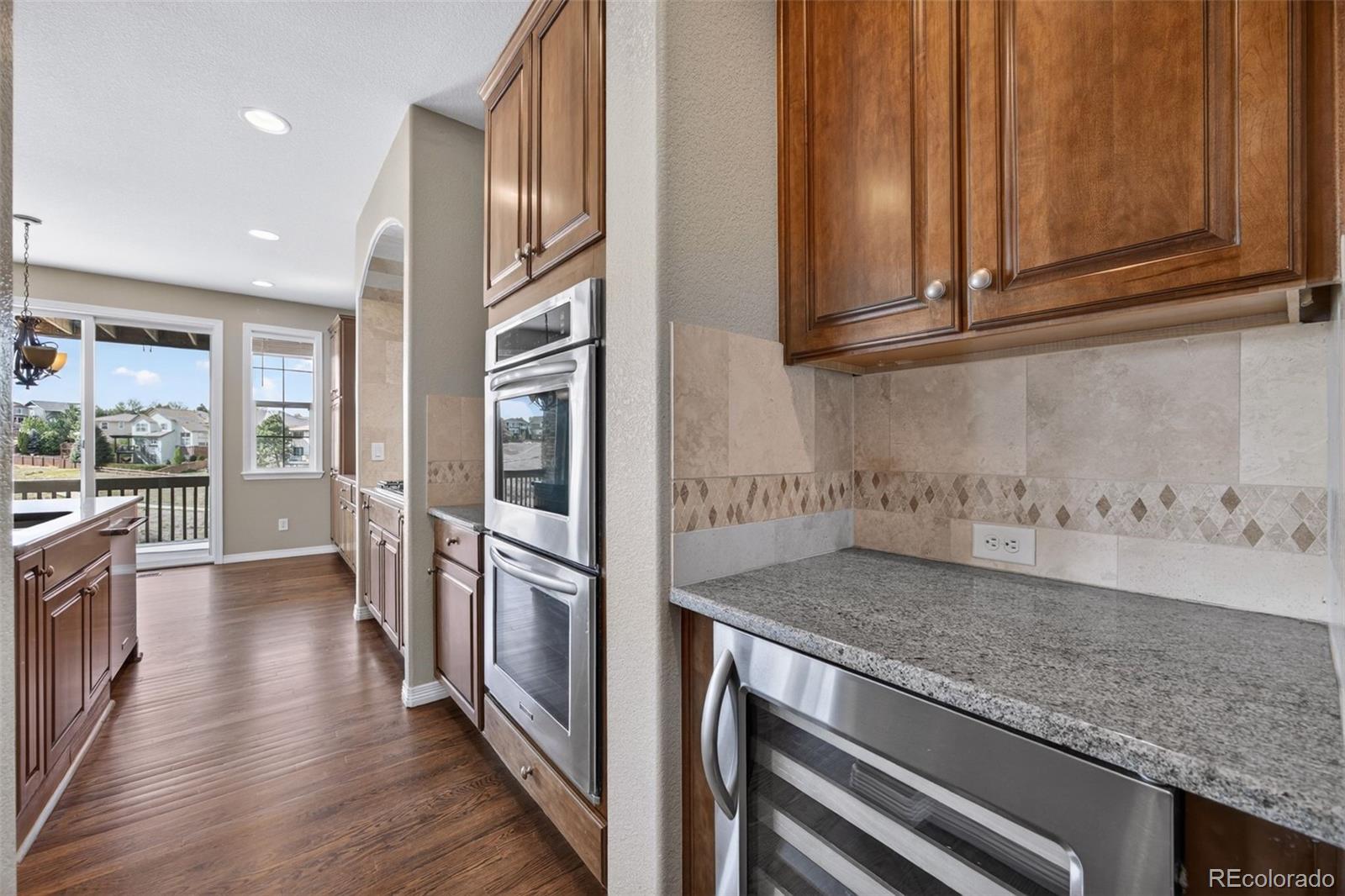 10872 Valleybrook Circle Highlands Ranch, CO 80130 - Photo 11 of 50 a kitchen with stainless steel appliances granite countertop a refrigerator and a sink