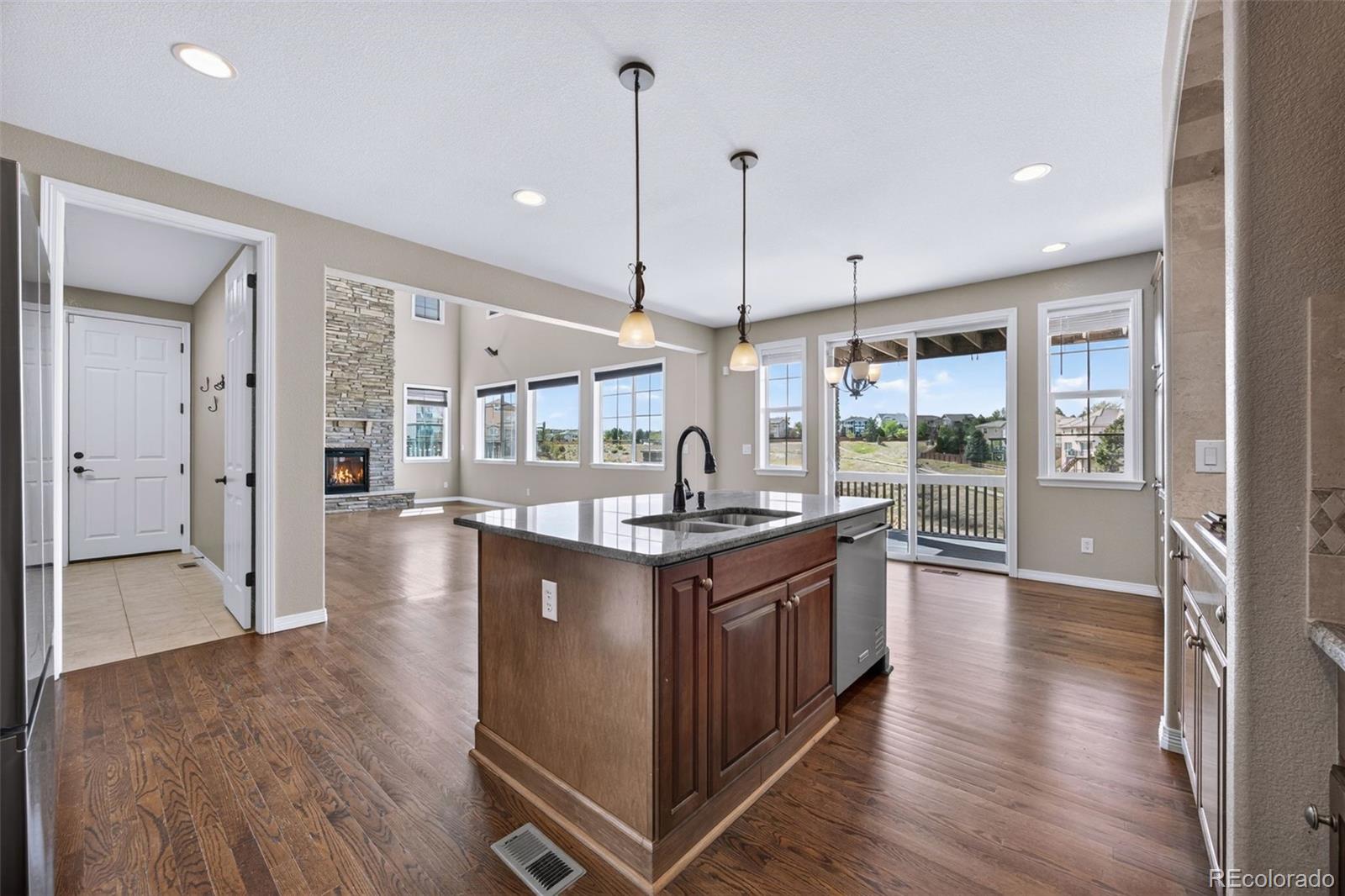 10872 Valleybrook Circle Highlands Ranch, CO 80130 - Photo 12 of 50 a kitchen with stainless steel appliances granite countertop a stove and a wooden floors