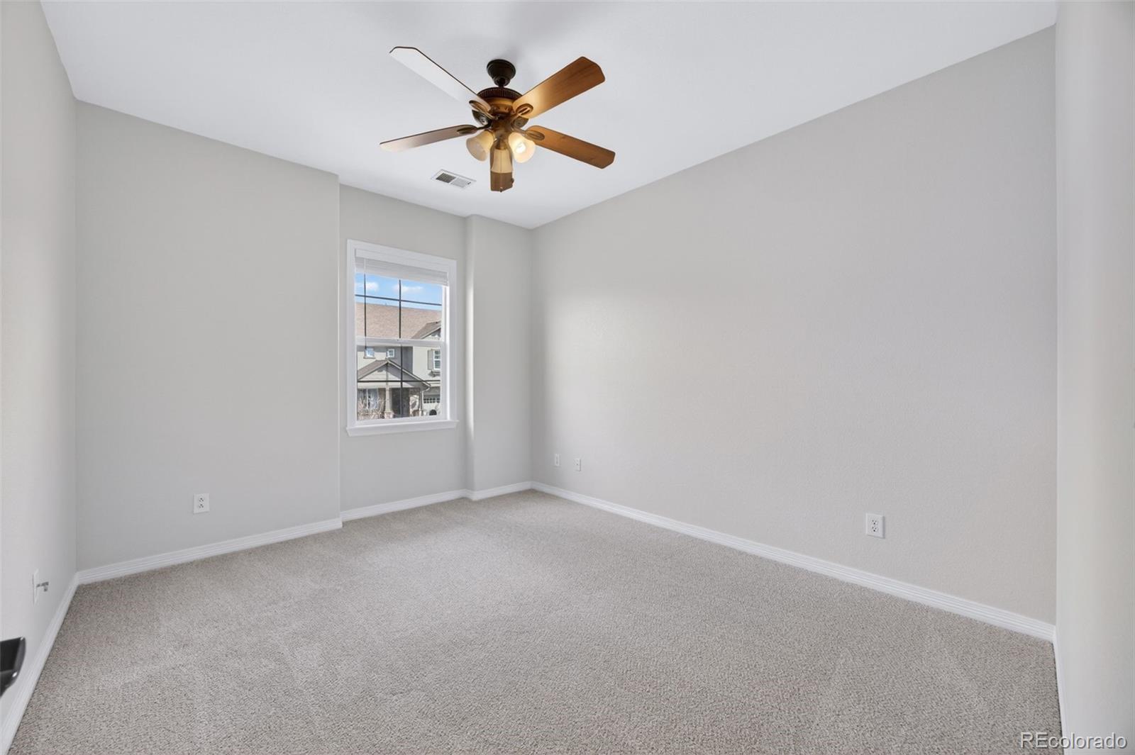 10872 Valleybrook Circle Highlands Ranch, CO 80130 - Photo 29 of 50 an empty room with a ceiling fan and window