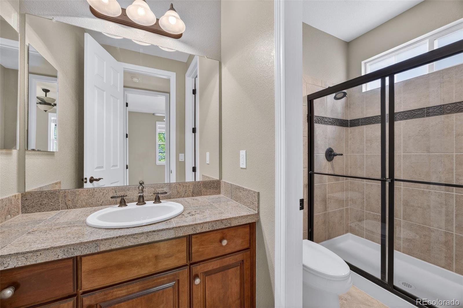 10872 Valleybrook Circle Highlands Ranch, CO 80130 - Photo 5 of 50 a bathroom with a sink and a mirror