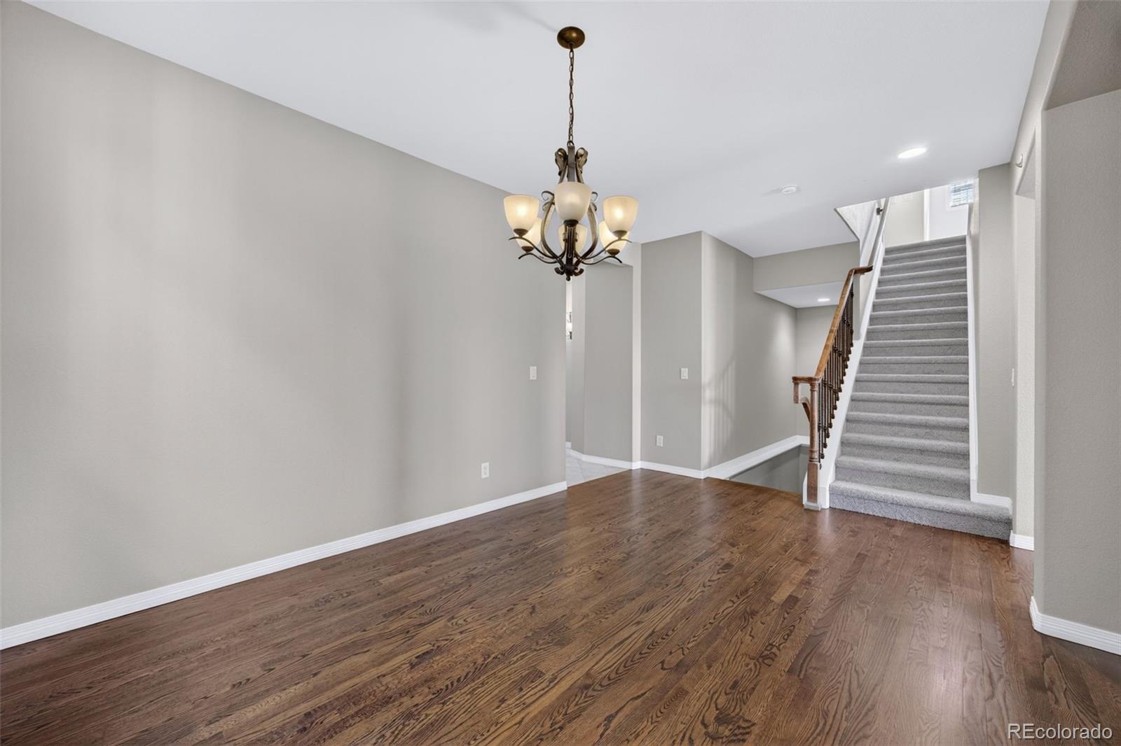 10872 Valleybrook Circle Highlands Ranch, CO 80130 - Photo 10 of 50 a view of a room with wooden floor staircase and a chandelier