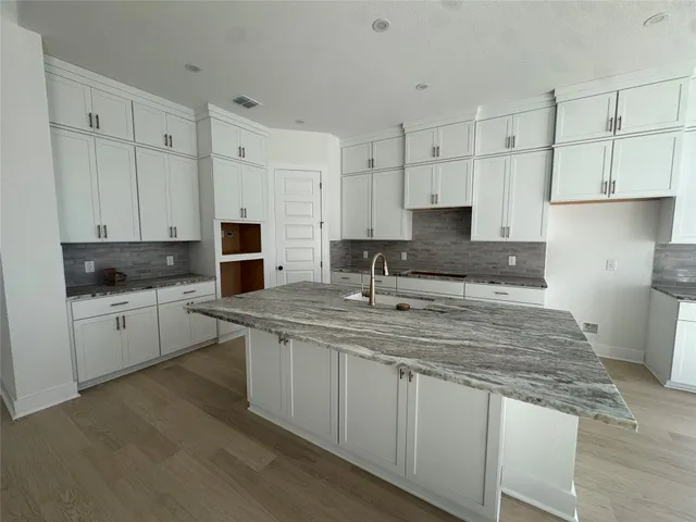 a kitchen with stainless steel appliances granite countertop a sink stove and white cabinets
