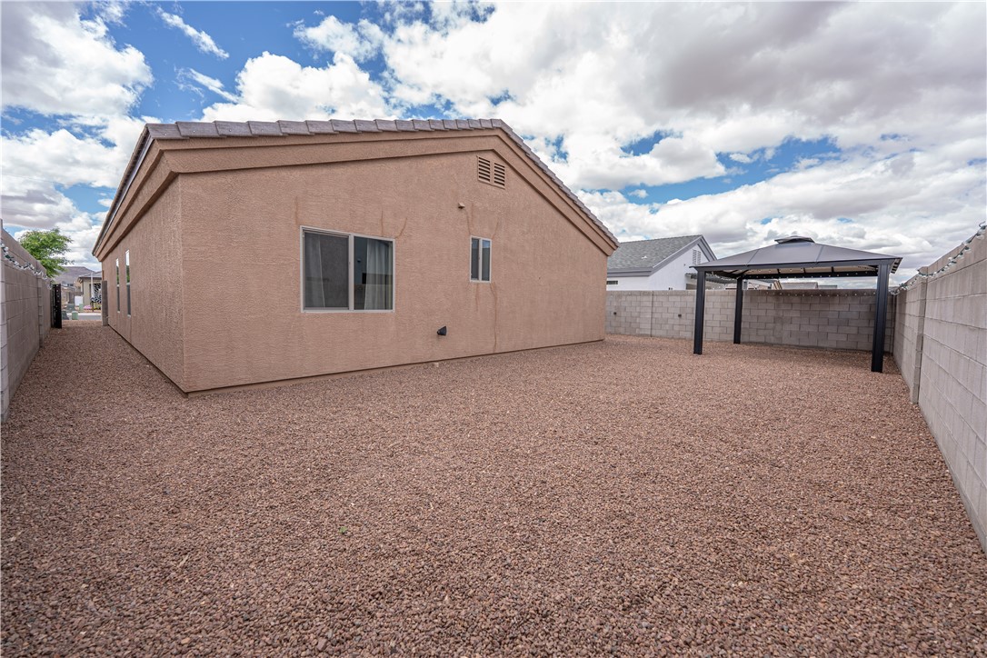 3546 North Kenneth Road Kingman, AZ 86409 - Photo 34 of 35 The property features a spacious rear yard with a gravel ground cover and a freestanding gazebo