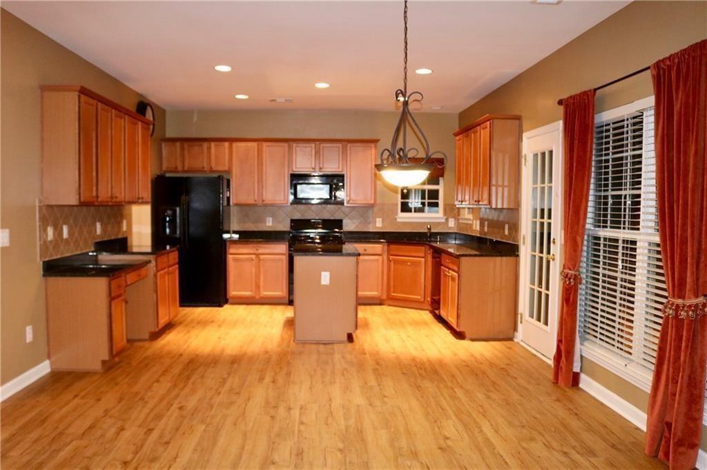 607 Hidden Close Woodstock, GA 30188 - Photo 2 of 11 a kitchen with stainless steel appliances granite countertop a refrigerator a sink dishwasher a stove and white countertops with wooden floor